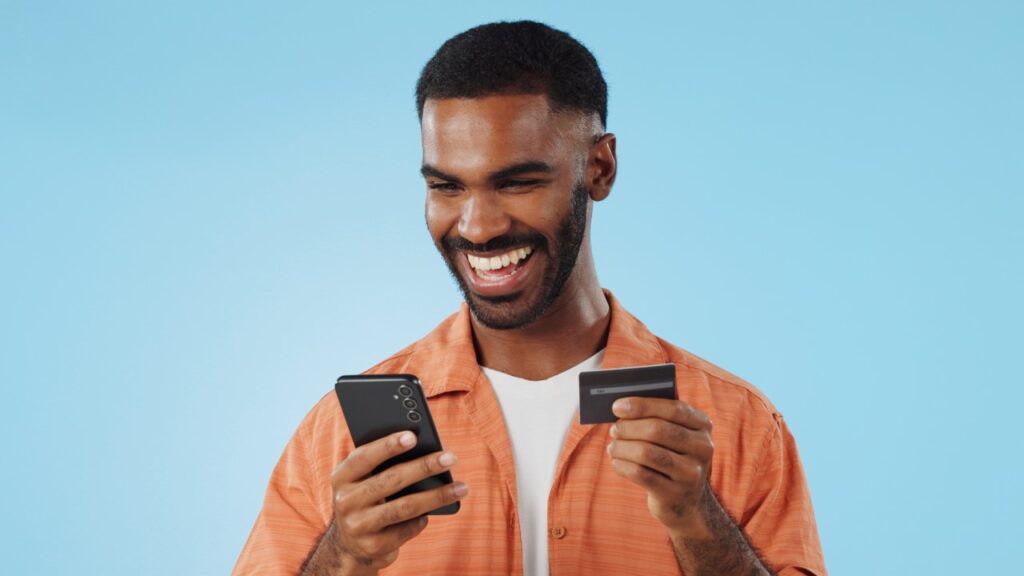 Man smiling holding credit card